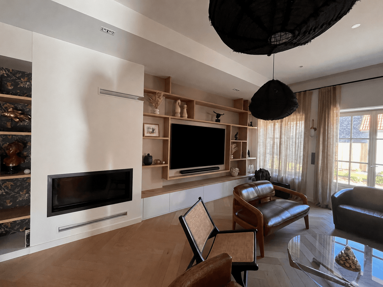 Salon avec meuble TV laqué blanc, bibliothèque chêne, cheminée insert et fauteuils en cuir, projet Port-Louis A4 Créations